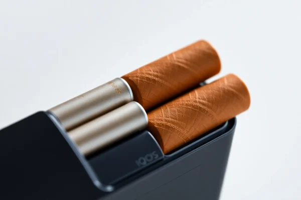 Heets sigara tobacco sticks being used with an IQOS device, highlighting product design and usage for easy smoking alternatives.
